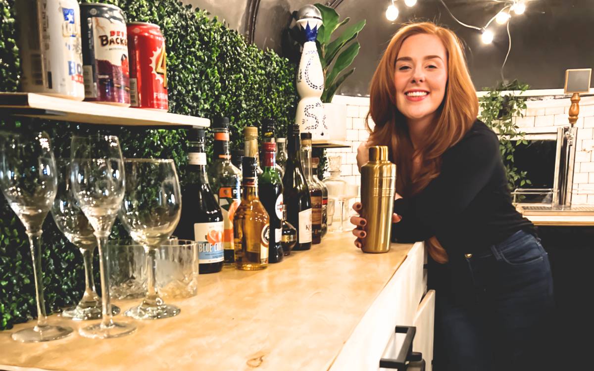 Rebecca Berry, co-owner of Beyond The Bar ATX, smiles inside the mobile bar trailer