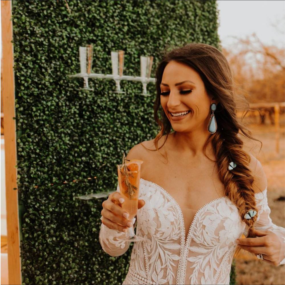 A bride smiling with a champagne cocktail with Beyond the Bar ATX mobile bar service